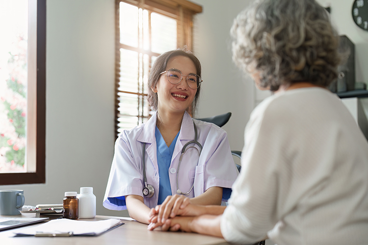 Female primary care physician having conversation with older woman.