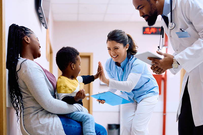 Woman doctor nurse giving young Medicare patient a high-five