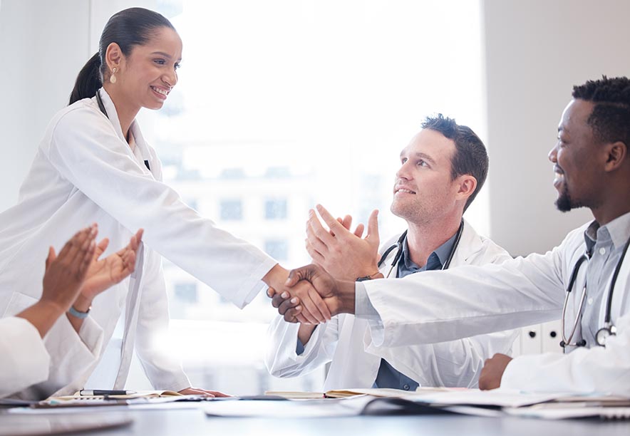Doctors and staff clapping about meeting value-based care goals